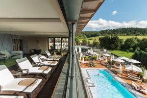 einen Balkon mit Liegestühlen und einem Pool in der Unterkunft Göbels Schlosshotel "Prinz von Hessen" in Friedewald