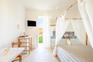a bedroom with a bed and a desk and a window at Masseria Rauccio in Torre dell'Orso