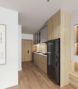 a kitchen with a black refrigerator and wooden cabinets at Khách sạn LAzur in Cửa Lô