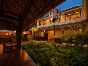 a building with a patio with a table and lights at Villa Khili Phousi in Luang Prabang