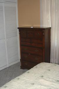 a bedroom with a dresser and a bed at Cozy Apartment in Kingston