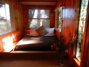a small bed in a room with a window at Mount Joy Cottages in Knysna