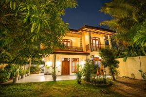 a large house with a courtyard at night at The Clouds Ahangama in Ahangama