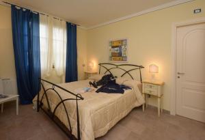 - une chambre dotée d'un lit avec un cadre noir et des rideaux bleus dans l'établissement Casa Cardinali, à Pienza