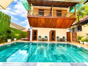 a house with a swimming pool with a balcony at Villa Khili Phousi in Luang Prabang