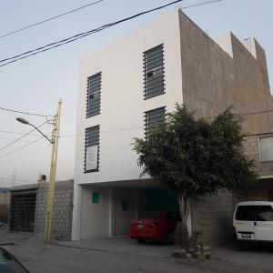 Biały budynek z czerwonym samochodem zaparkowanym przed nim w obiekcie La Siesta del Patron w mieście Querétaro