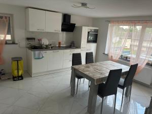 a kitchen with a wooden table and a table and chairs at Ferienhaus Nine in Oberthal
