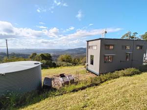 a small house on a hill with a trailer at Bottletree Gardens Mini Mansion Red in Lower Beechmont
