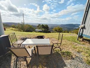 a table and chairs sitting on top of a field at Bottletree Gardens Mini Mansion Red in Lower Beechmont