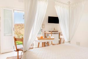 a bedroom with a bed and a table and a window at Masseria Rauccio in Torre dell'Orso