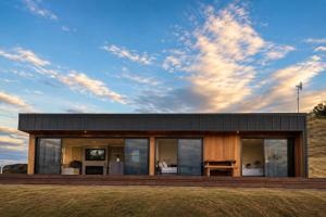 a modern house with a black roof at Ocean Waters in Mahia
