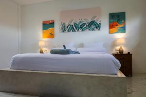 a bedroom with a large white bed with two lamps at Swell Hotel, Pool Bar & Restaurant in Tanah Lot +69 photos