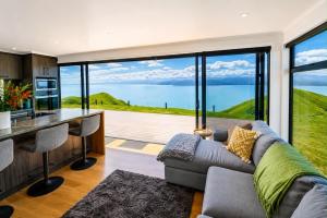 a living room with a couch and a large window at Ocean Waters in Mahia