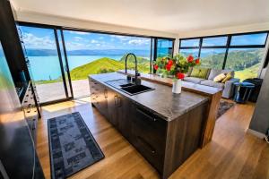a kitchen with a sink and a living room with a couch at Ocean Waters in Mahia