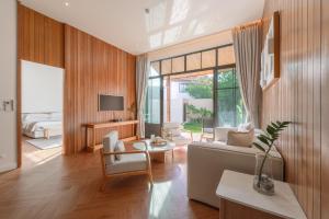 a living room with a couch and a tv at Saturdays Residence by Brown Starling in Rawai Beach