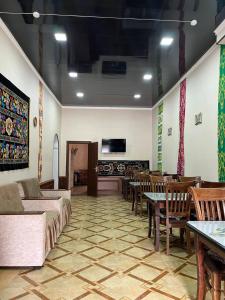 a living room with a couch and tables and chairs at Polvon Ota Hotel in Khiva
