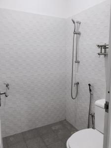 a bathroom with a toilet and a shower at Anorawi Surf accommodation in Maluk +9 photos