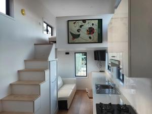 a living room with a staircase and a kitchen at Bottletree Gardens - Mini Manson Blue in Gold Coast