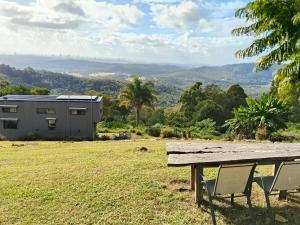 a picnic table and two chairs in a field at Bottletree Gardens - Mini Manson Blue in Gold Coast
