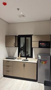 eine Küche mit Spüle und Kühlschrank in der Unterkunft هاوس تو 21 in Abha