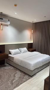 ein Schlafzimmer mit einem großen weißen Bett darin in der Unterkunft هاوس تو 21 in Abha