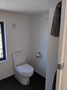 a bathroom with a white toilet and a window at Bottletree Gardens - Mini Manson Blue in Gold Coast +45 photos