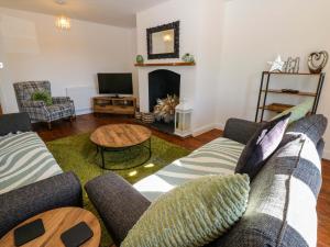 a living room with two couches and a television at Blacksmiths Cottage in Alnwick