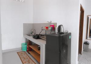 a kitchen with a black refrigerator in a room at Anorawi Surf accommodation in Maluk