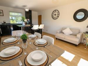 a dining room with a table with plates and wine glasses at Blacksmiths Cottage in Alnwick