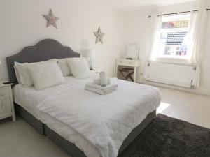 a bedroom with a large white bed with stars on the wall at Blacksmiths Cottage in Alnwick