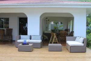 a patio with two couches and a table and a living room at Beach Kaz in Takamaka