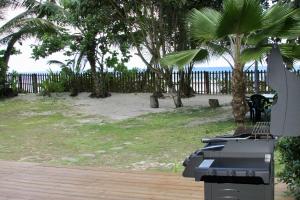 Blick auf einen Strand mit Palmen und einem Zaun in der Unterkunft Beach Kaz in Takamaka