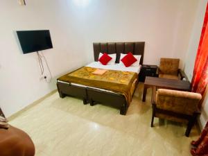 a bedroom with a bed and a tv and a chair at Fab Krishna hotal in Panchkula