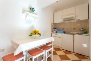 una cocina con una mesa y algo de fruta. en Apartments Slavica, en Pomena