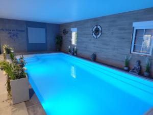 a large swimming pool with a blue lighting in a house at Au Rêve en Somme in Hautvillers-Ouville