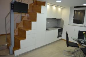 a staircase in a room with a table and a kitchen at Apart FL in Mirandela