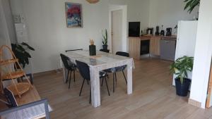a table and chairs in a room with a kitchen at L'Hibiscus-Joli T3-70m2- Terrasse-Jardin in Entre-Deux +16 photos