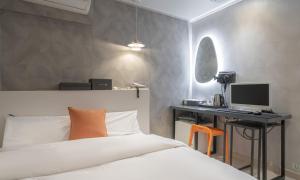 a bedroom with a bed and a desk with a computer at Uiwang Nine Hotel in Uiwang