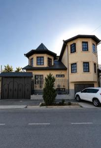 a white car parked in front of a house at Uyut house Osh in Osh