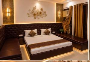 a bedroom with a large bed with a bench and a chandelier at Hotel Atithi Palace in Sahāranpur