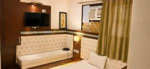 a living room with a couch and a television at Hotel Atithi Palace in Sahāranpur