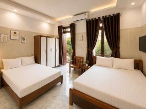 a bedroom with two beds and a television in it at Đại Thắng Hotel in Danang