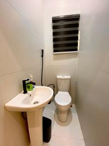 a white bathroom with a toilet and a sink at Aulein Apartments in Abuja +20 photos