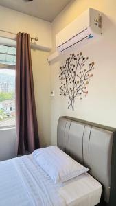 a bedroom with a bed with a fan and a window at Seaview Apartment in Kuah