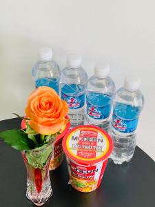 a flower in a vase next to bottles of water at Guest house Trung Hiếu in Rạch Giá +16 photos