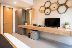a bedroom with a tv on a wall at Casananta Seminyak in Seminyak