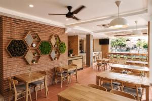 a restaurant with wooden tables and chairs and a brick wall at Casananta Seminyak in Seminyak +18 photos