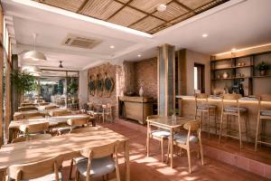 a restaurant with tables and chairs and a bar at Casananta Seminyak in Seminyak