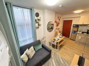a living room with a couch and a large window at H4R1 Luxe Haven in Bacolod