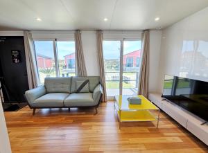 a living room with a couch and a flat screen tv at Udo Chano Village in Jeju